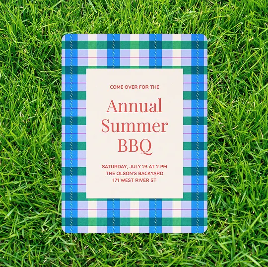 Invitation on blue and green plaid card on grass to Annual Summer BBQ July 23 at 2 PM at Olson's backyard.