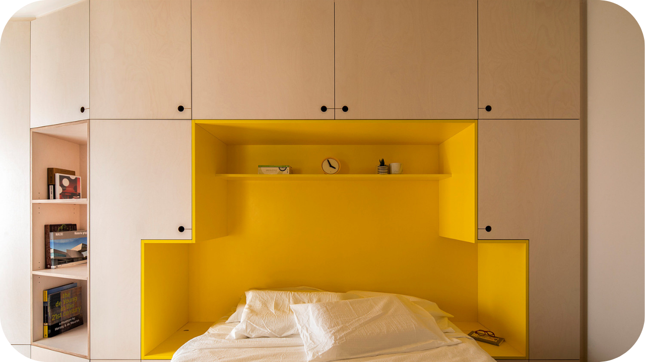 Modern Melbourne joinery style with light cabinetry, bold yellow bed alcove, shelving, and built-in storage design.