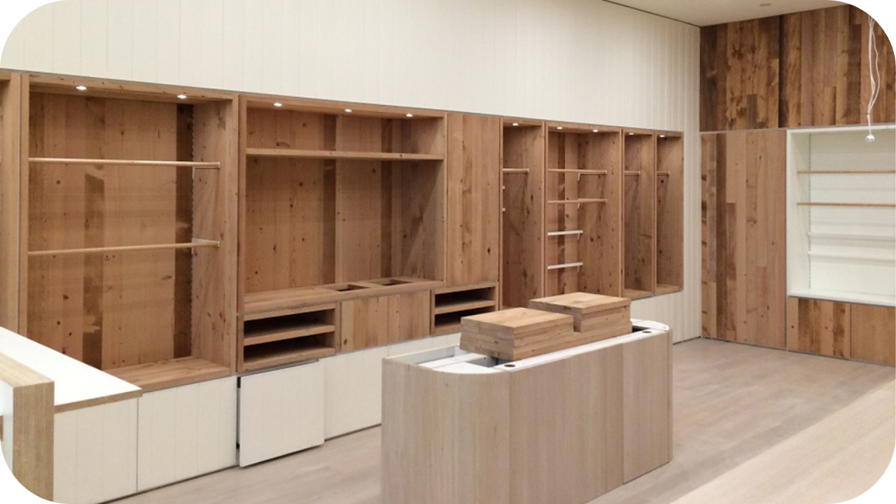 Custom retail fit-out with timber shelving, display units, storage cabinets, and feature lighting in a modern shop interior.