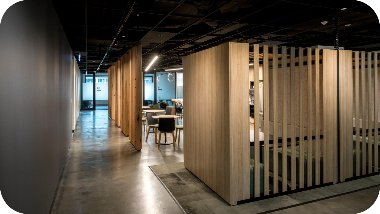 Modern Melbourne office fit out with timber partition walls, polished concrete floors, and collaborative seating, showcasing contemporary joinery.