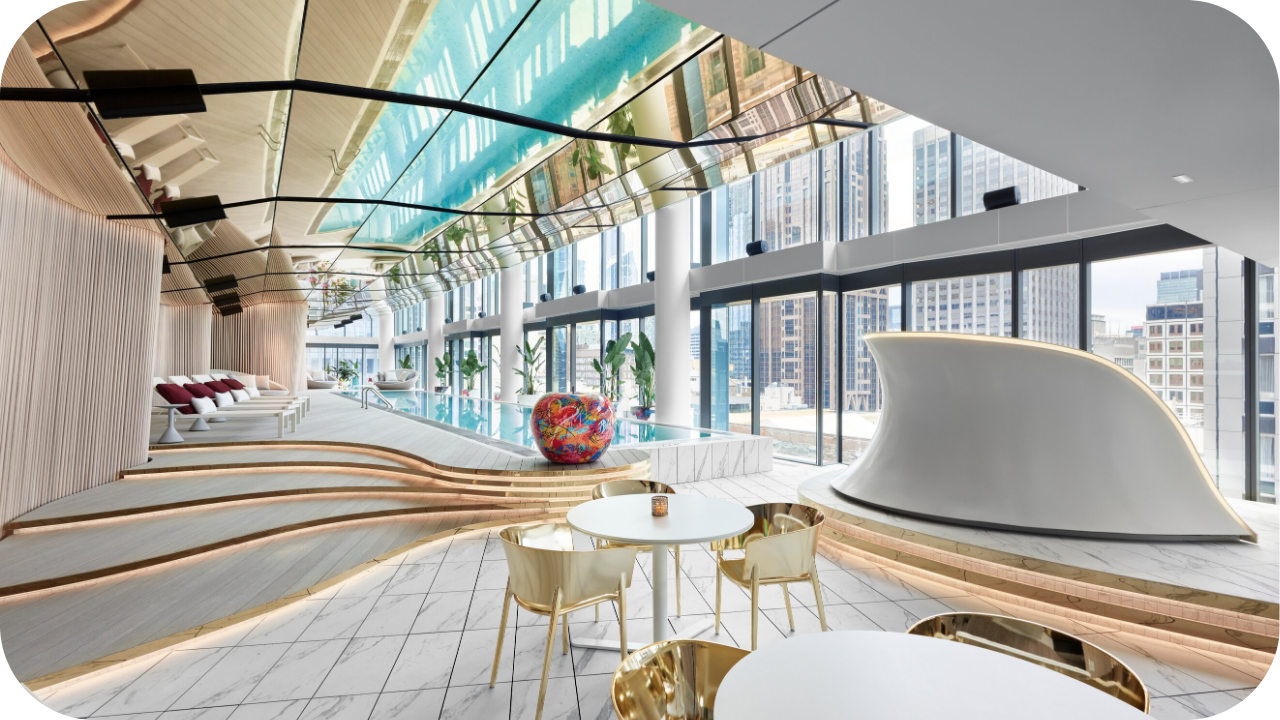 Luxury hospitality fit-out with indoor pool, city views, marble flooring, gold chairs, and modern lounge spaces, offering a premium guest experience.