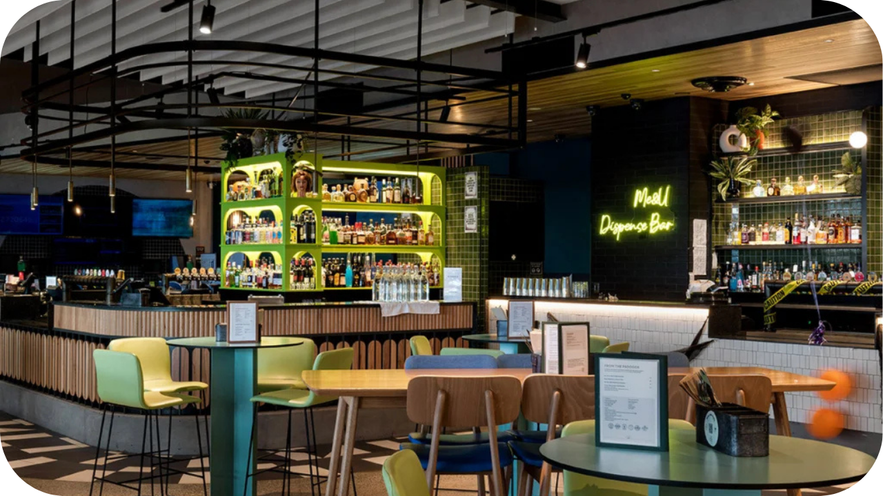 Vibrant hospitality fit out with modern bar, neon signage, colourful seating, and timber details creating a stylish and welcoming guest space.