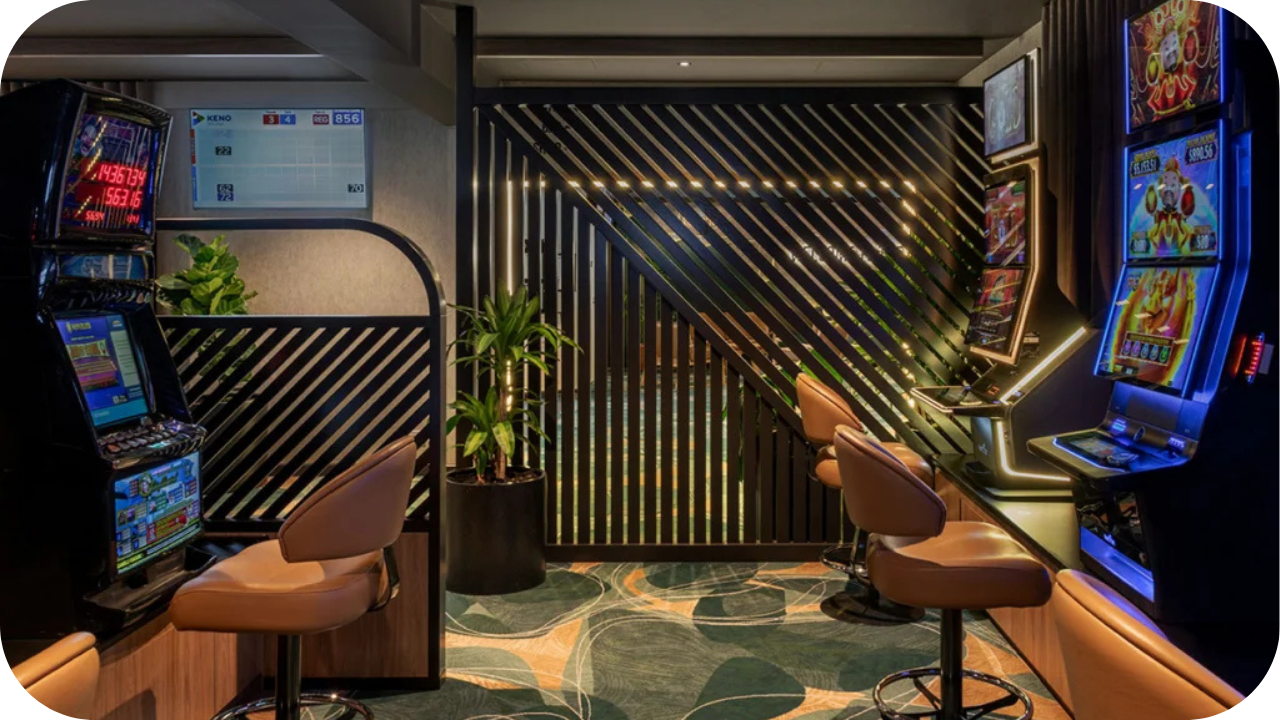 Gaming fit out with slot machines, cosy leather chairs, and ambient lighting against a sleek timber feature wall.