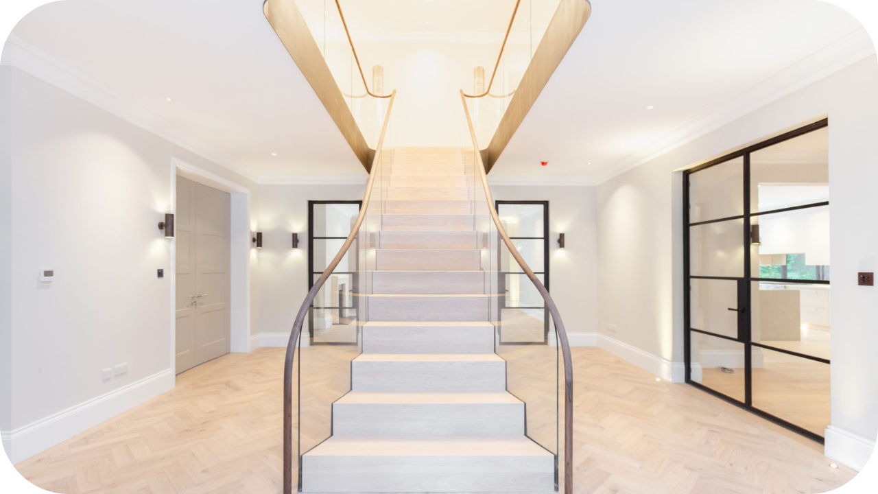 Bright interior with curved timber staircase, glass railing, and contemporary joinery details.