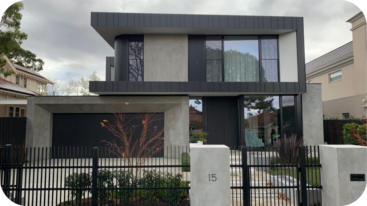 Luxury residential Melbourne home with sleek façade, black joinery accents, and modern architectural design framed by a landscaped front yard.