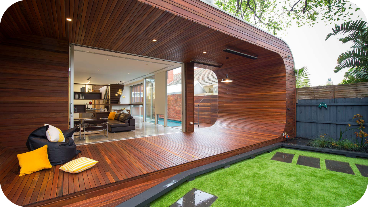 Outdoor living space with curved timber joinery, open transition to indoors, and green garden area for modern entertaining.