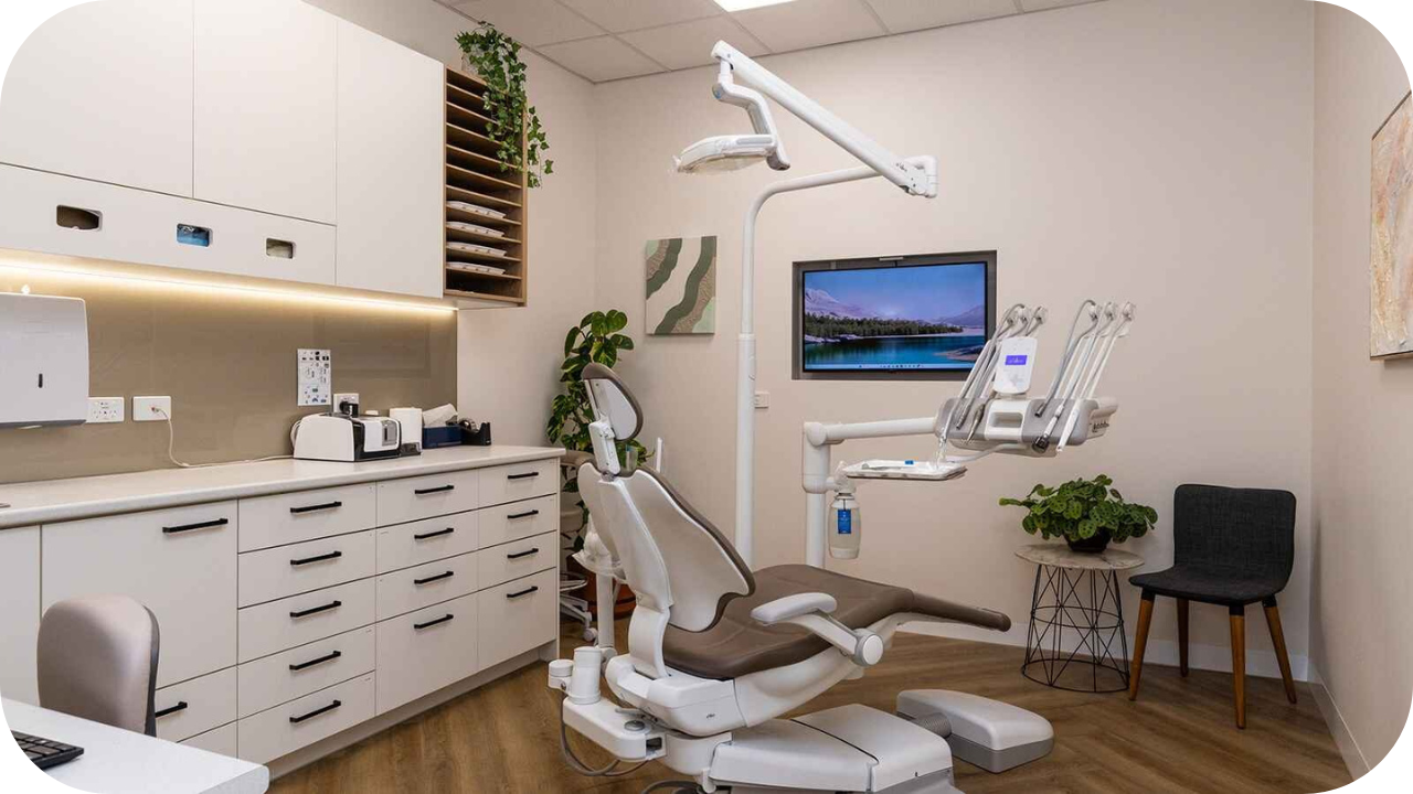 Dental surgery room with ergonomic dental chair, overhead light, custom cabinetry, and modern joinery finishes.