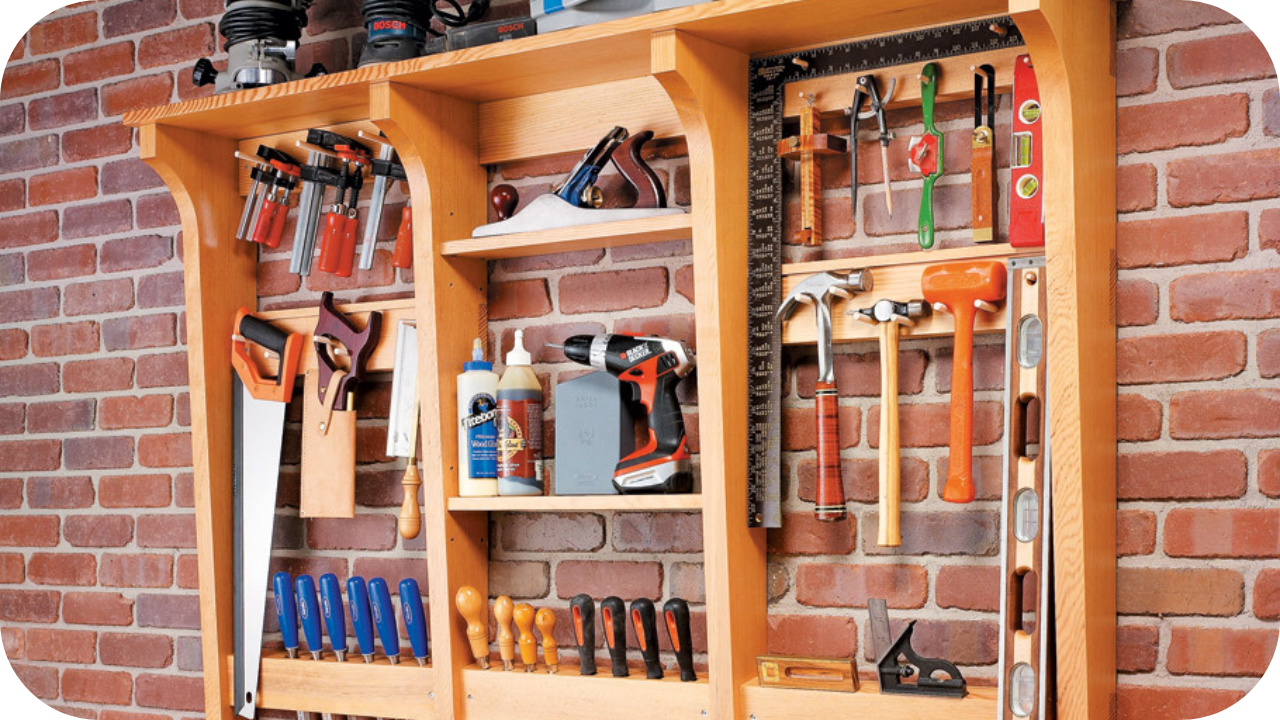 Wall-mounted wooden joinery system with shelves and tool holders, providing organised storage against a red brick wall.