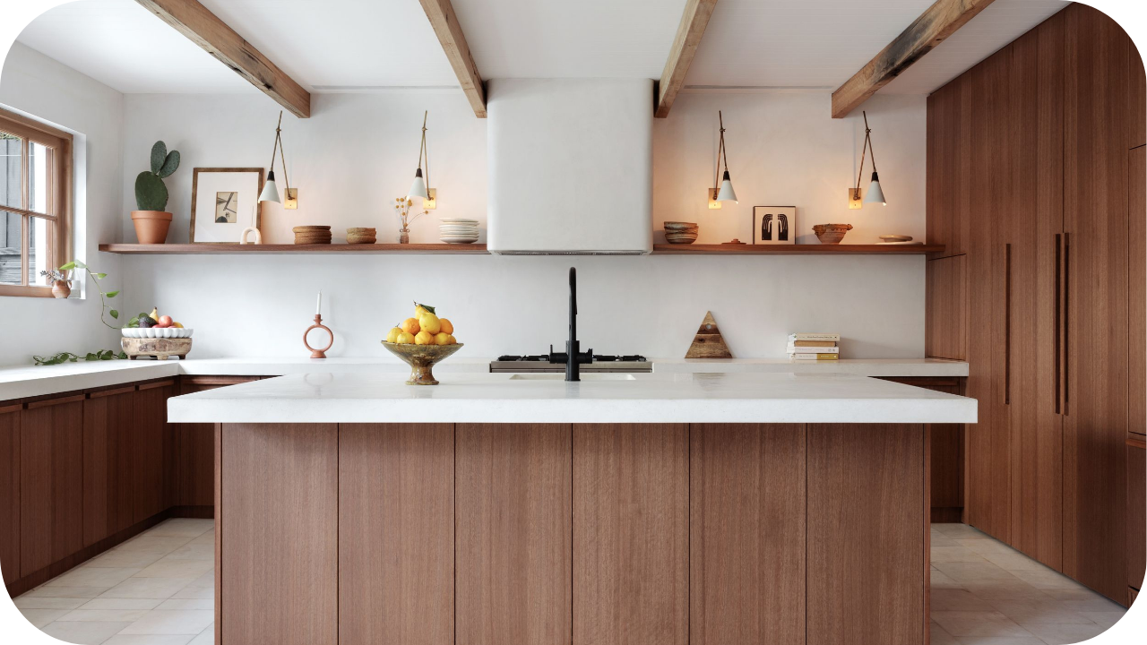 Warm timber kitchen with custom joinery, integrated cabinetry, open shelving, pendant lighting, and a large island bench showcasing high-end craftsmanship and design.