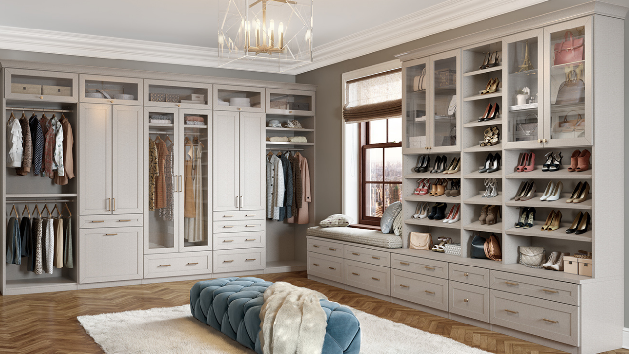Elegant walk-in wardrobe with custom joinery, glass front cabinets, open shelving and a window seat showcasing luxury interior craftsmanship.