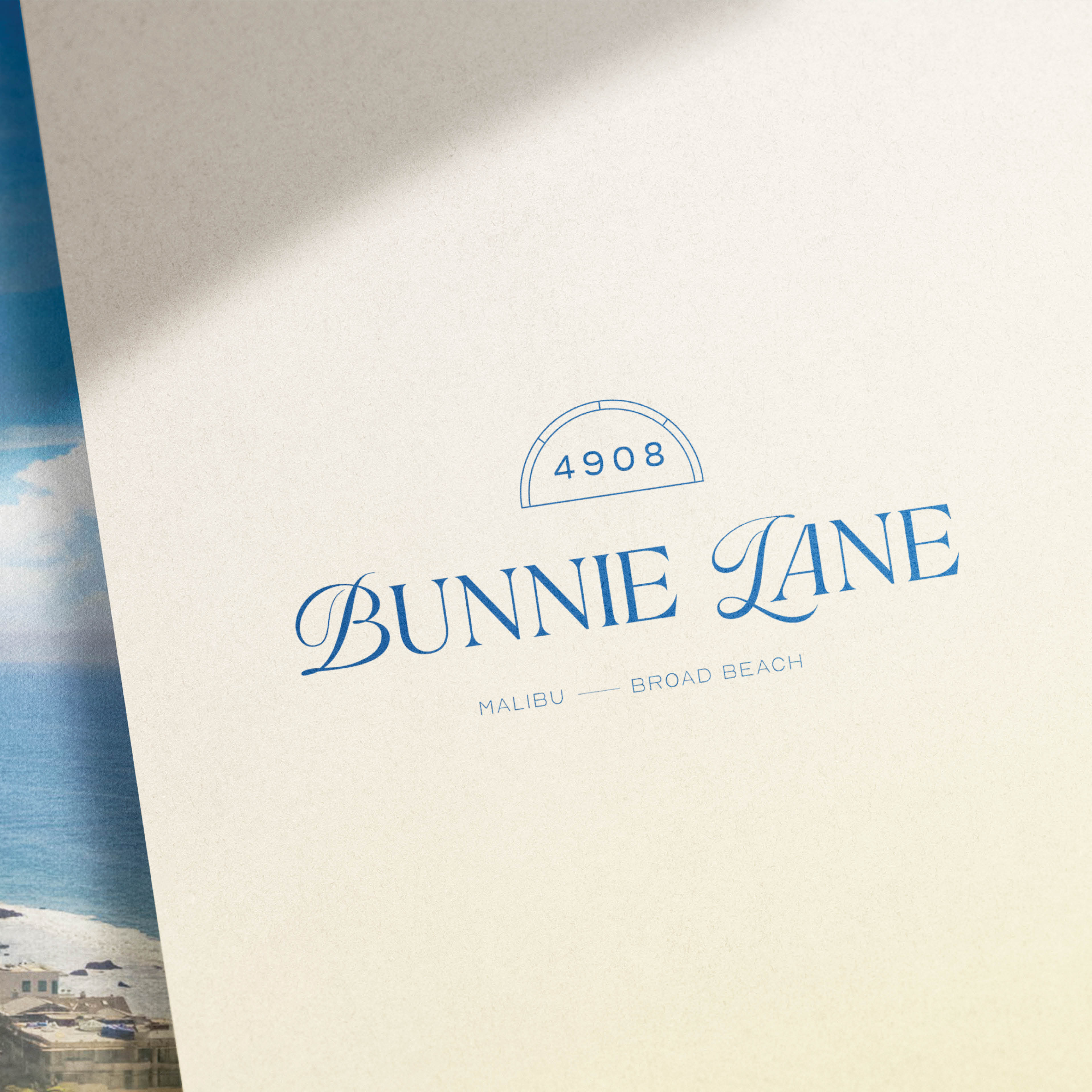 A logo design with the text 'Bunnie Lane' in elegant blue script, number 4908 above, and 'Malibu — Broad Beach' below.