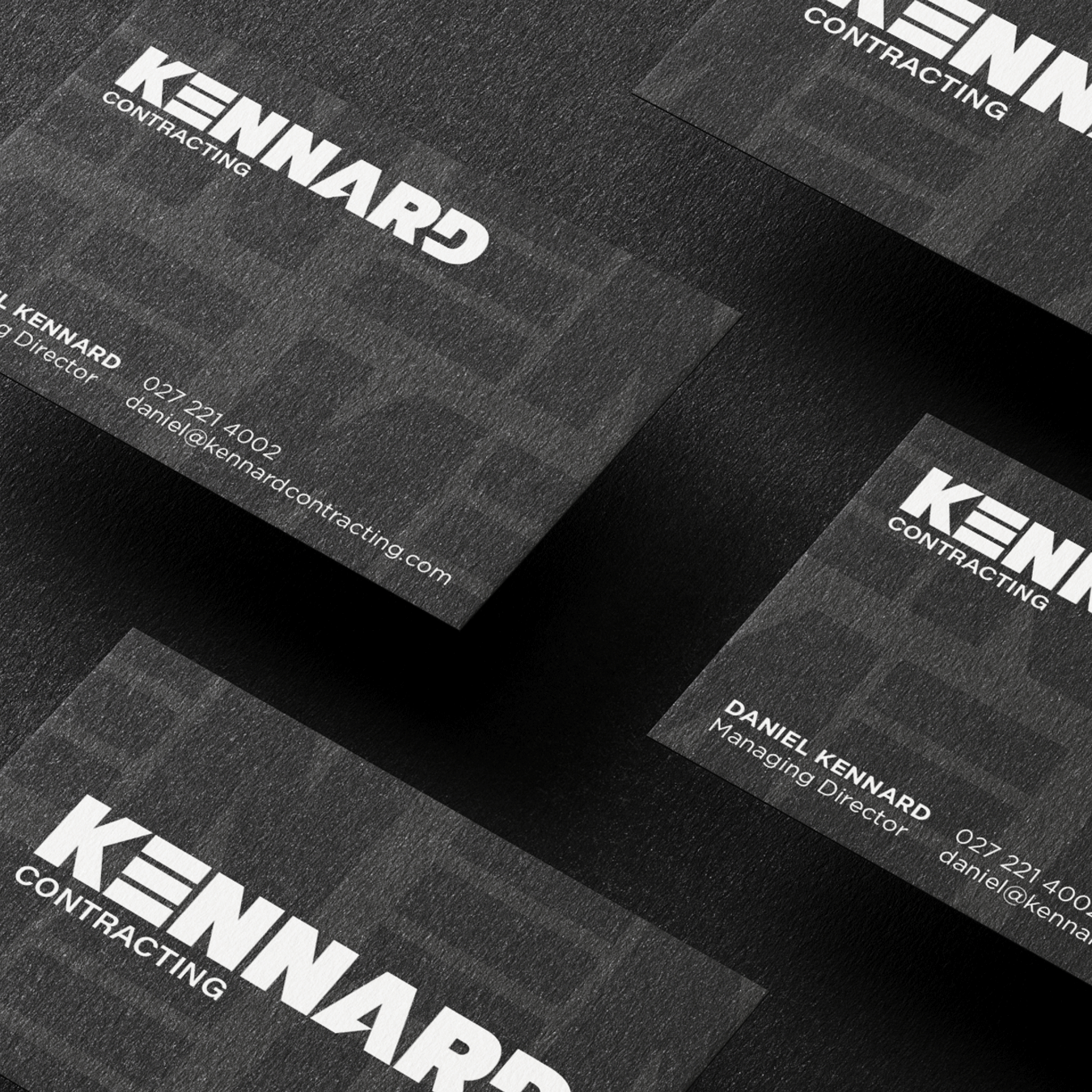 Black business cards with white bold text reading 'KENNARD CONTRACTING' and contact details for Daniel Kennard, Managing Director.