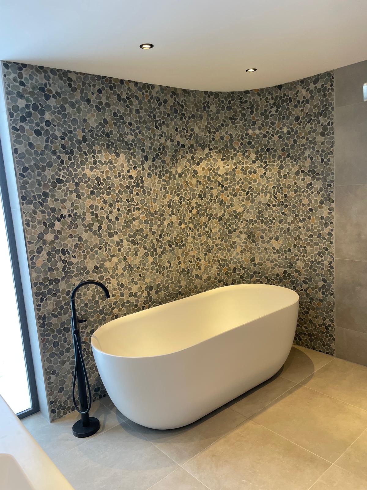 Badkamer met moaziek en vrijstaand bad.