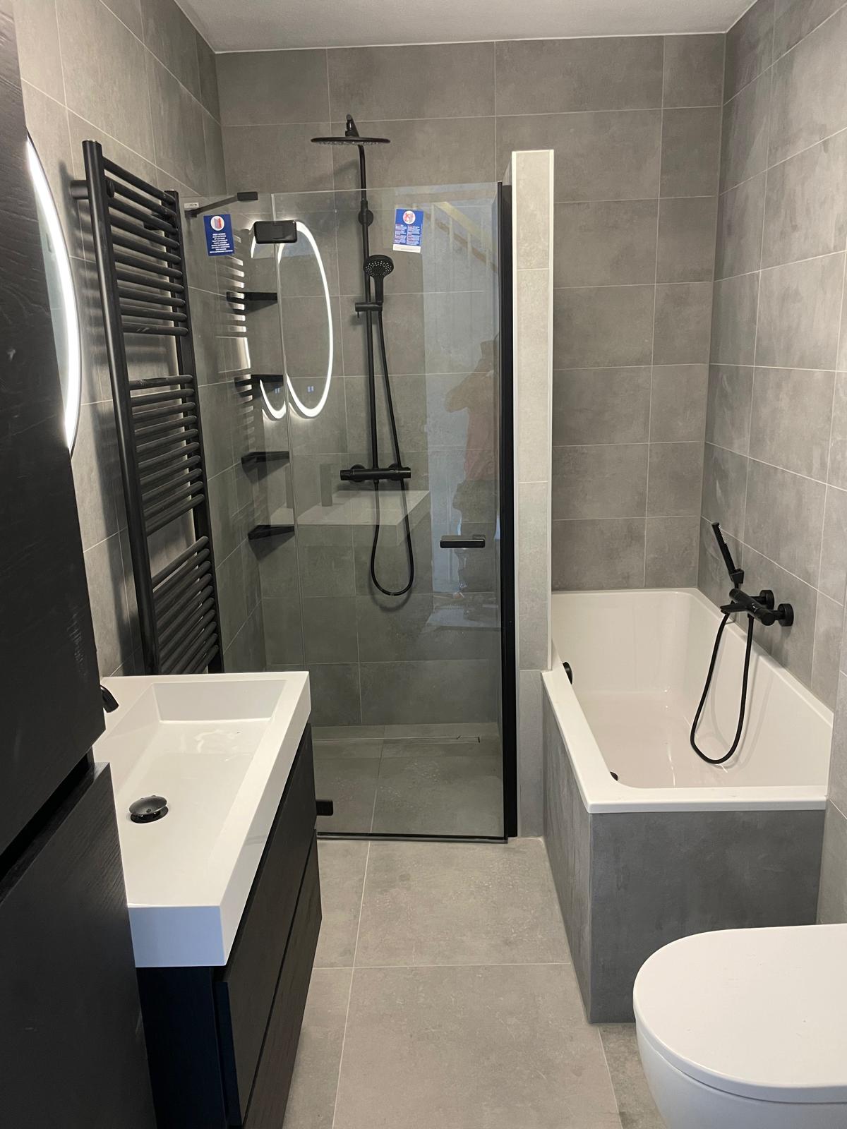 Badkamer grijs met bad.