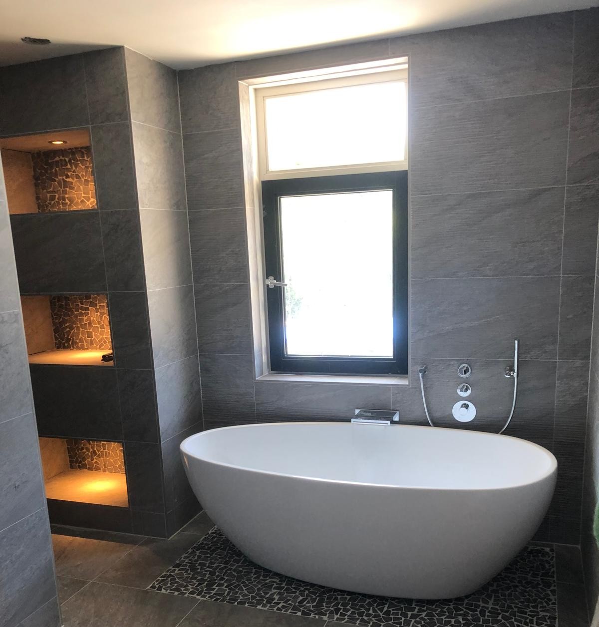 Badkamer met bad en nisjes.