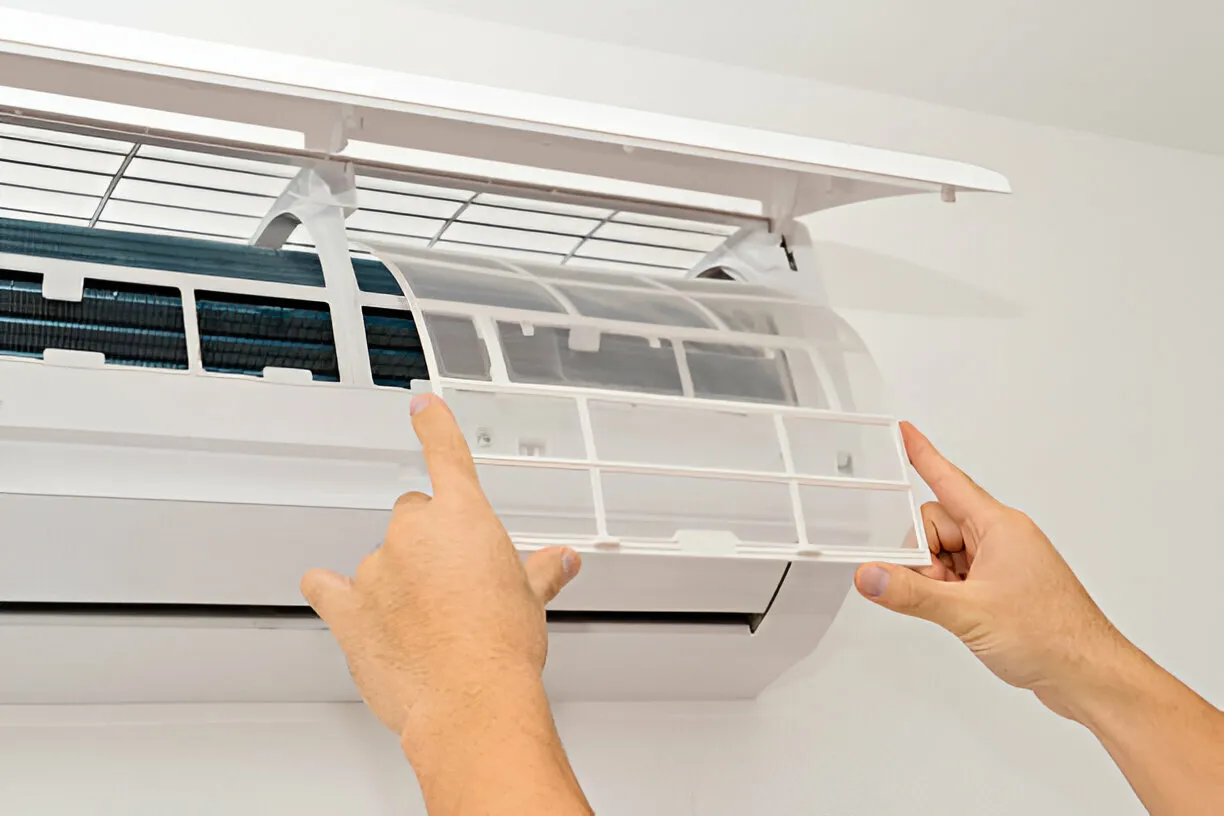 Hands removing AC filter.