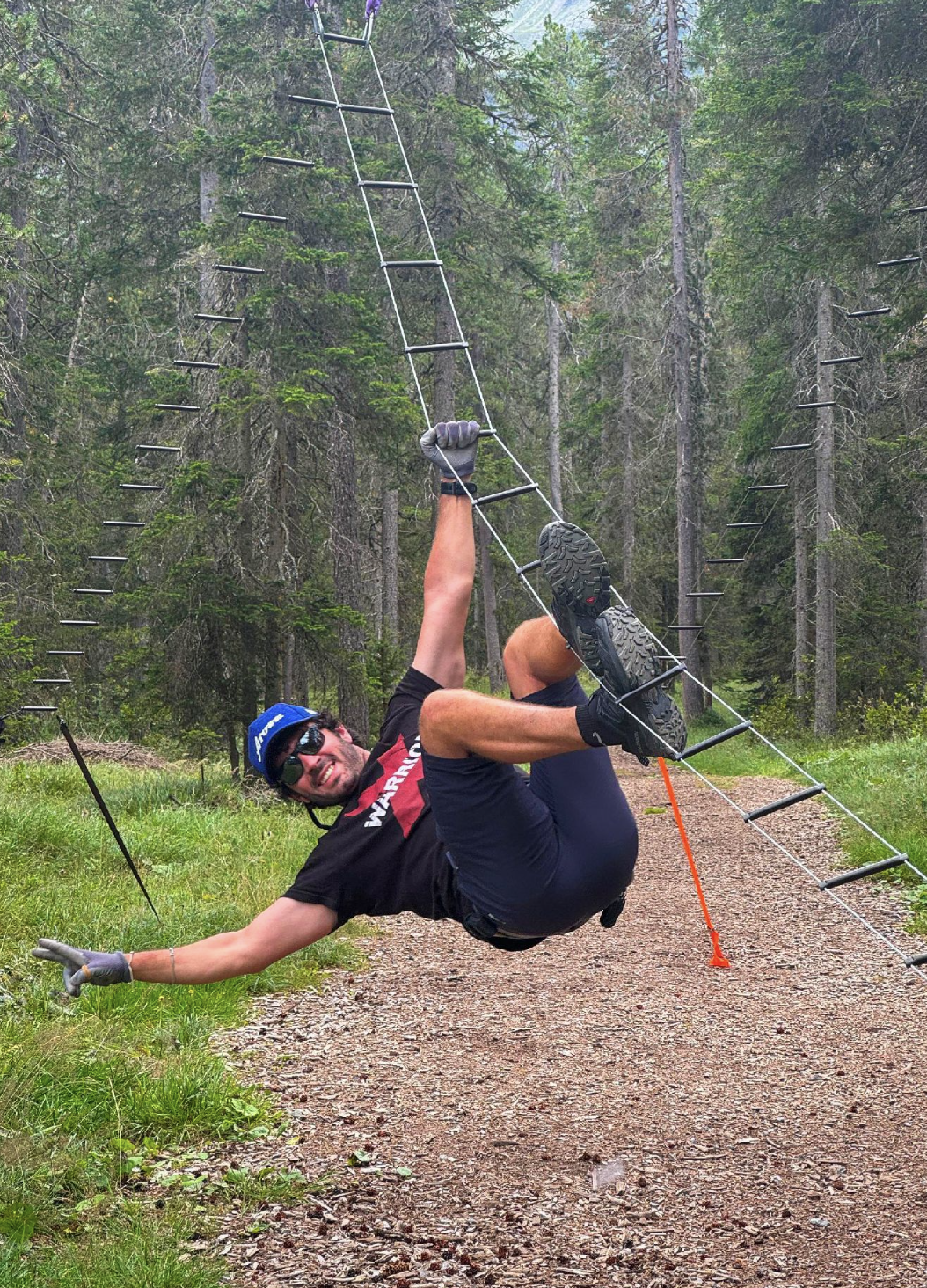 Carlo Maresca at the x-warirors event hanging in an obstacle while smiling and having fun