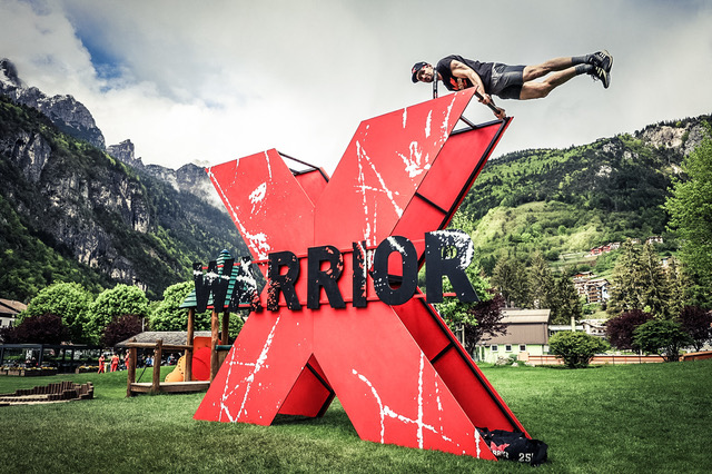 Atleta in cima alla grande X rossa X-Warrior nel villaggio gara di Molveno