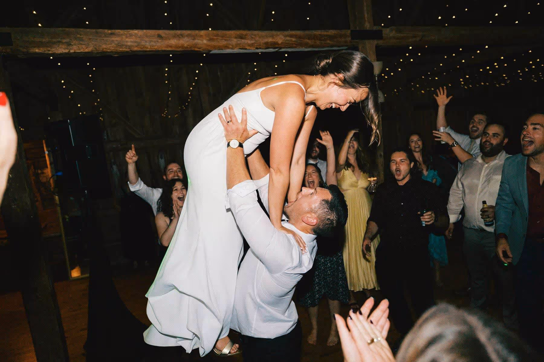 groom lift bride into the air while dancing at their wedding reception in Maine