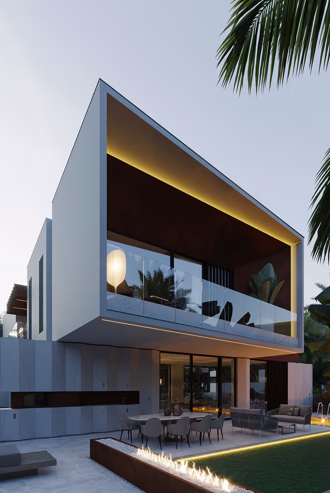 Modern two-story house with an illuminated balcony, outdoor seating area, fireplace, and palm trees at dusk.