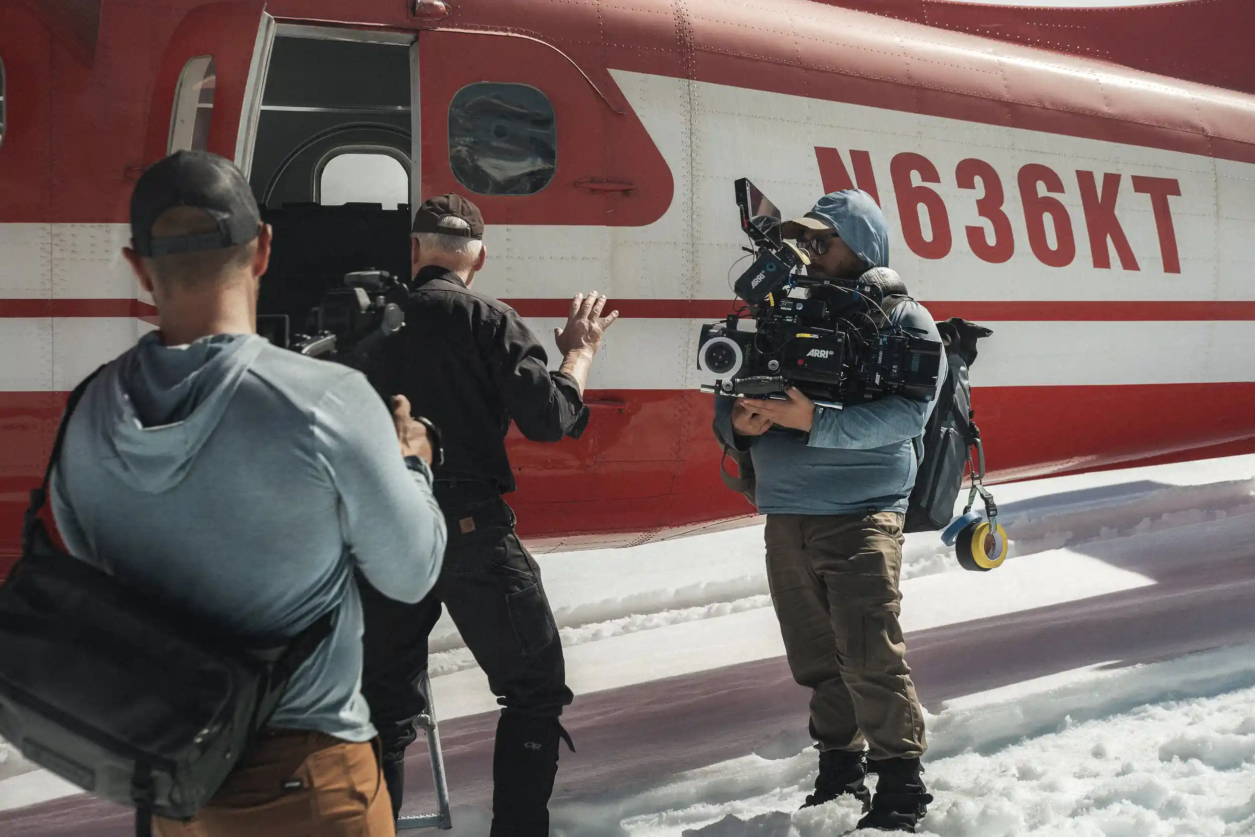 Camera operator builds ARRI Alexa as crew boards a DHC-3 Otter on snow in Alaska
