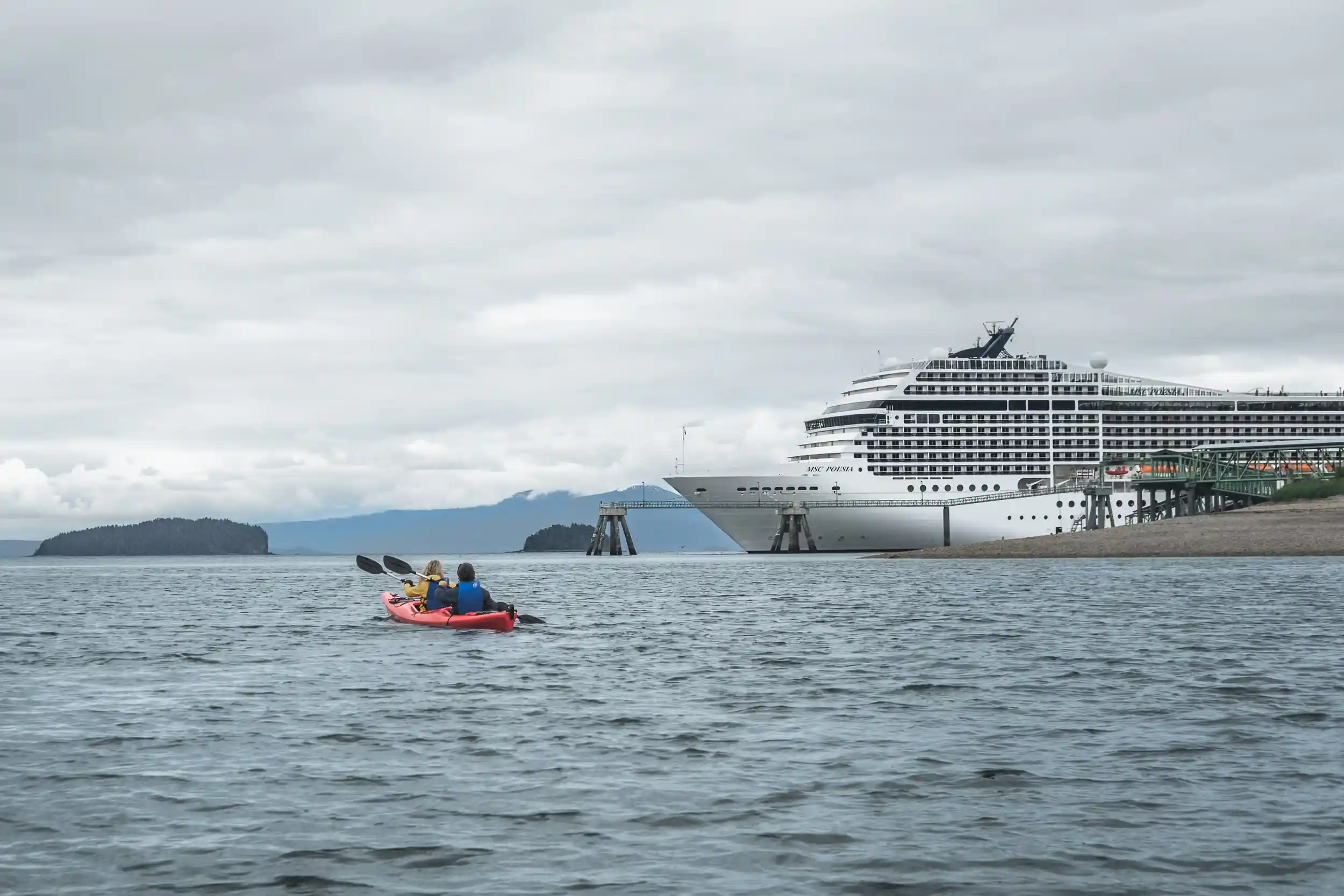 Kayakers paddling toward the MSC Poesia docked at Icy Strait Point, Alaska