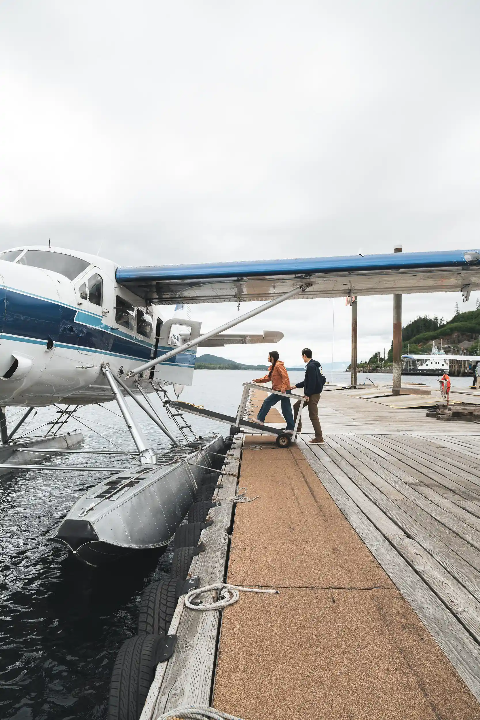 Couple boarding a floatplane at a wooden dock in Southeast Alaska