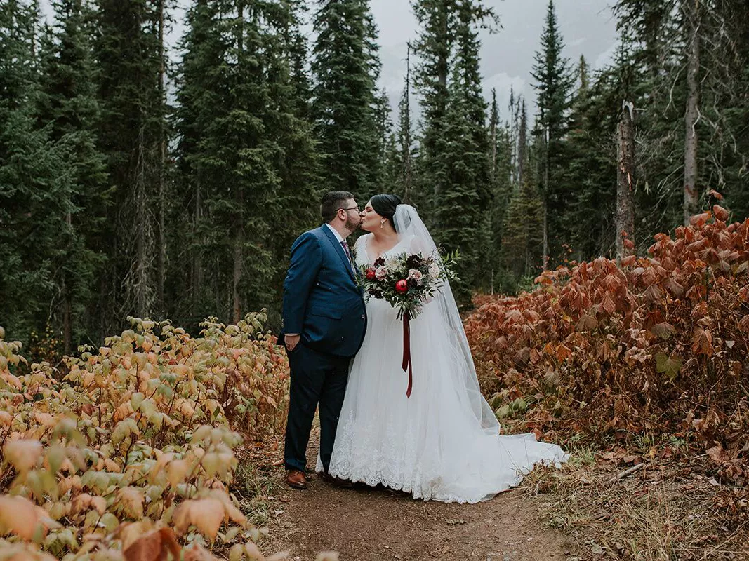 bride and groom kissing at a fall wedding