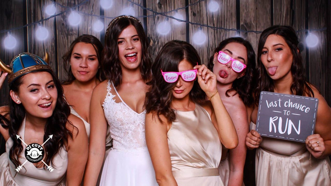 bridesmaids using props in a photo booth