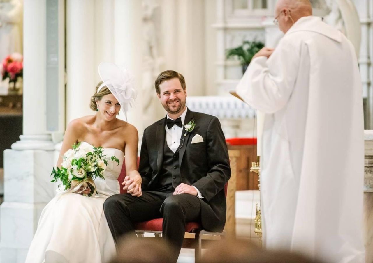 wedding couple holding hands at a catholic ceremony