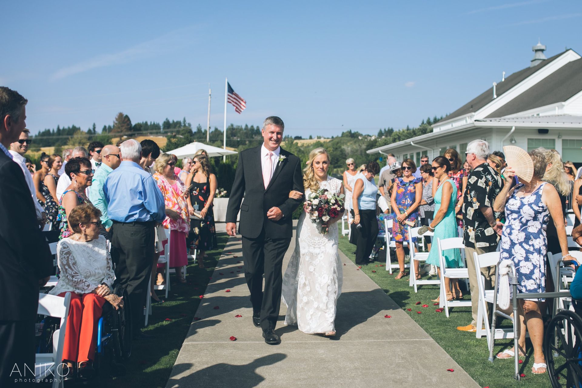 bride walking down the wedding aisle with father 