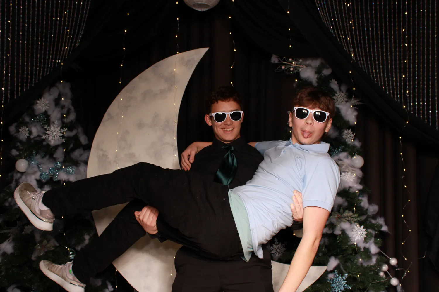 Two men wearing sunglasses and ties are posing for a picture.