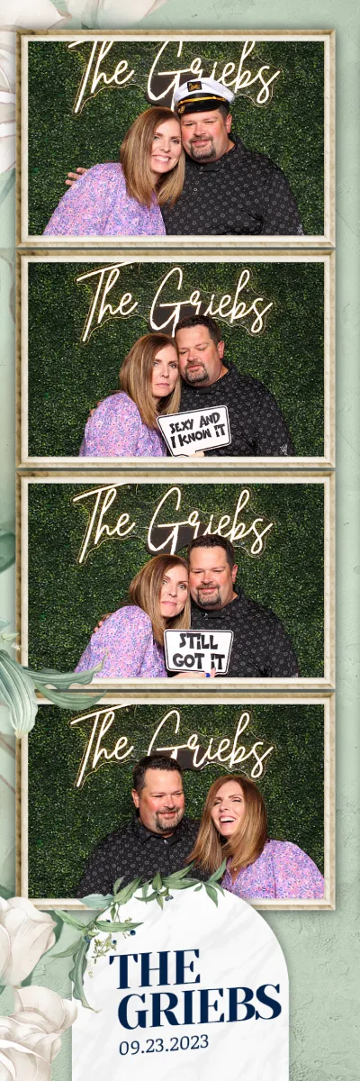 A man and woman pose for a picture with a sign that says "The Grizzles".