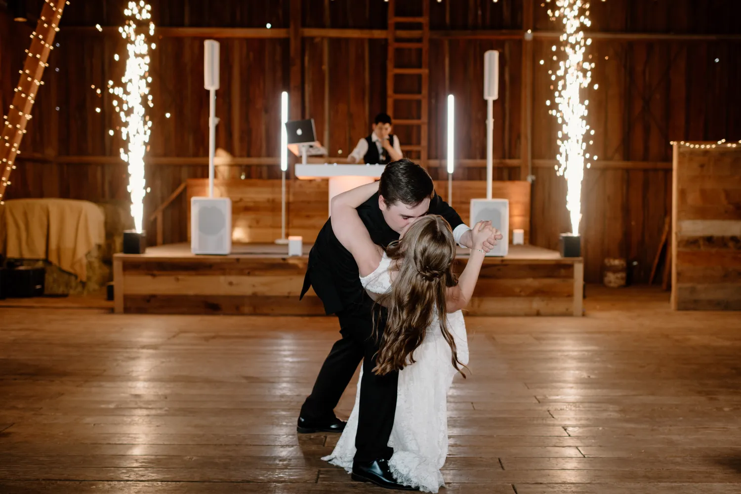 A man and woman dancing in a room with a DJ.