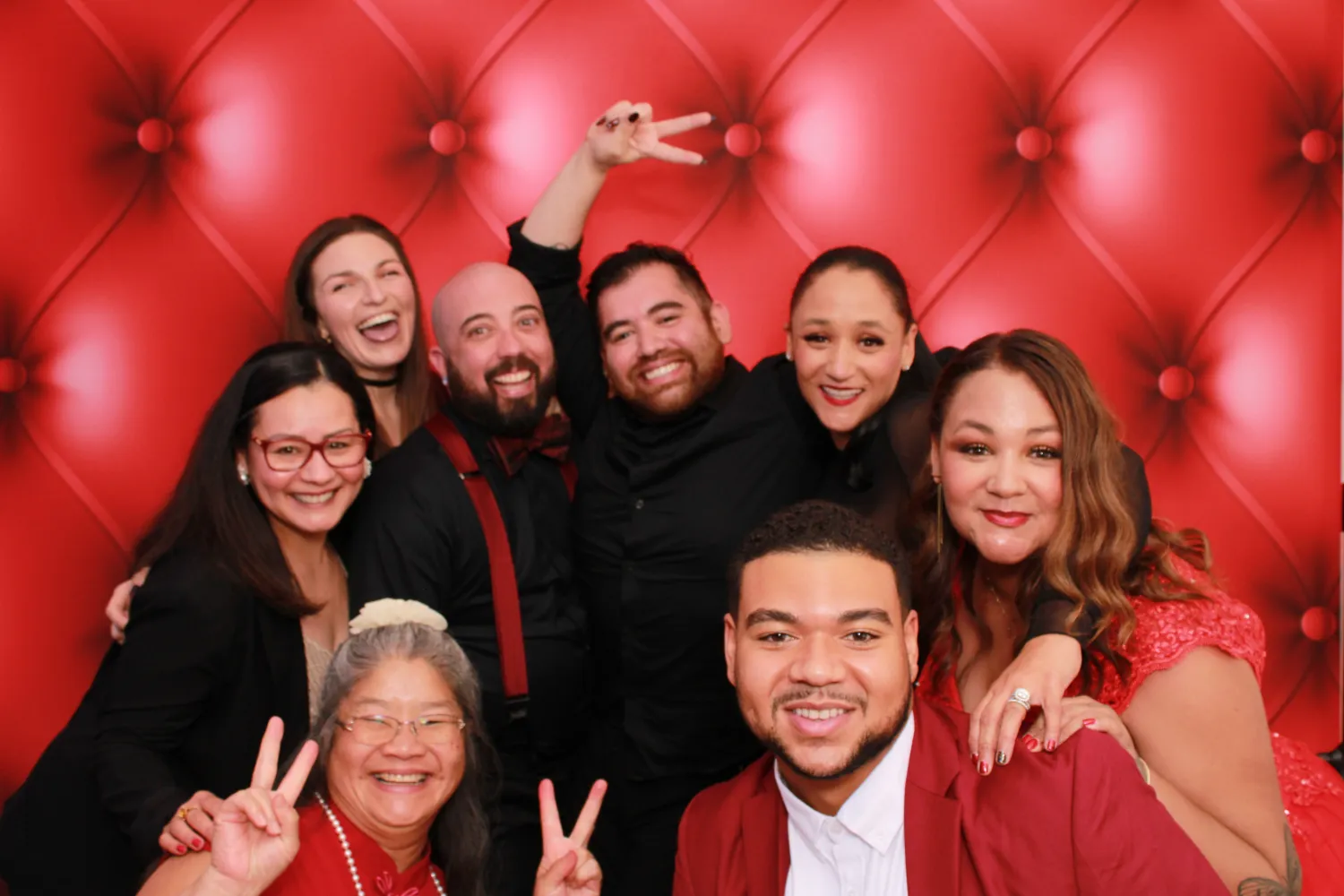 Joyful group photo with diverse people posing against red background