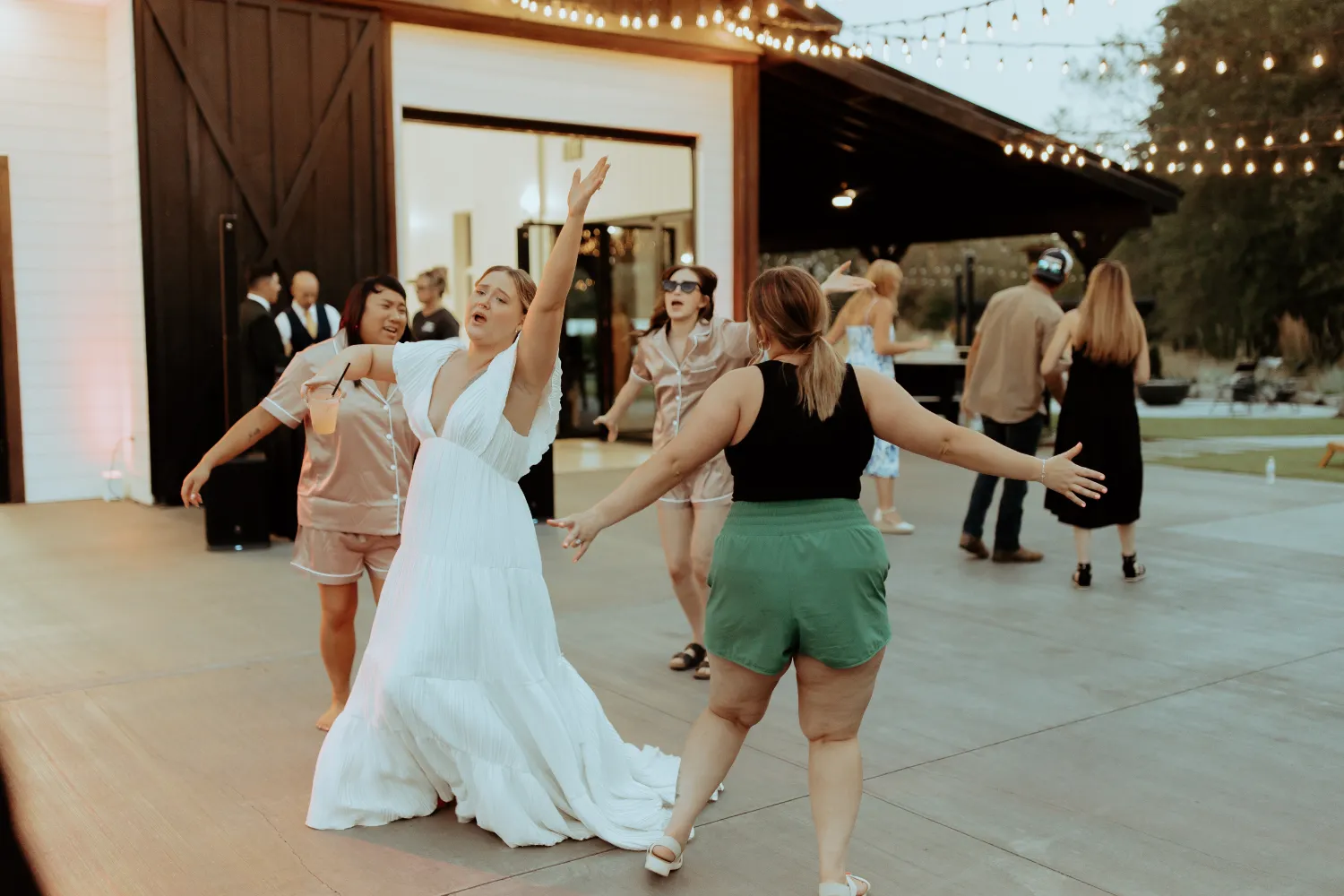 Wedding reception dance floor with bride in white dress celebrating joyfully