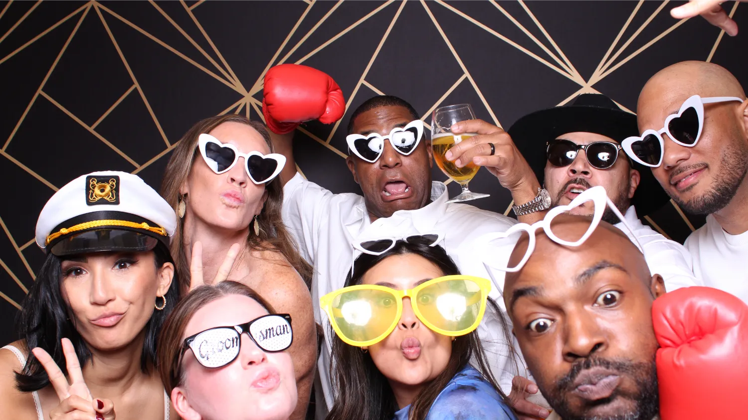 Fun group photo booth with silly sunglasses, boxing gloves, and beer
