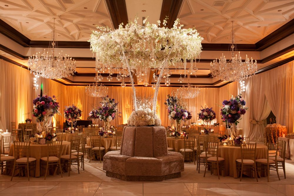 Elegant wedding reception with white floral centerpiece and crystal chandeliers