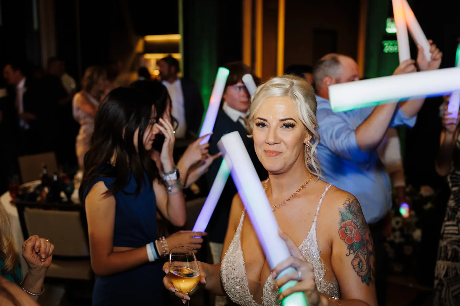 Guests celebrating with glowing light sticks at a festive event