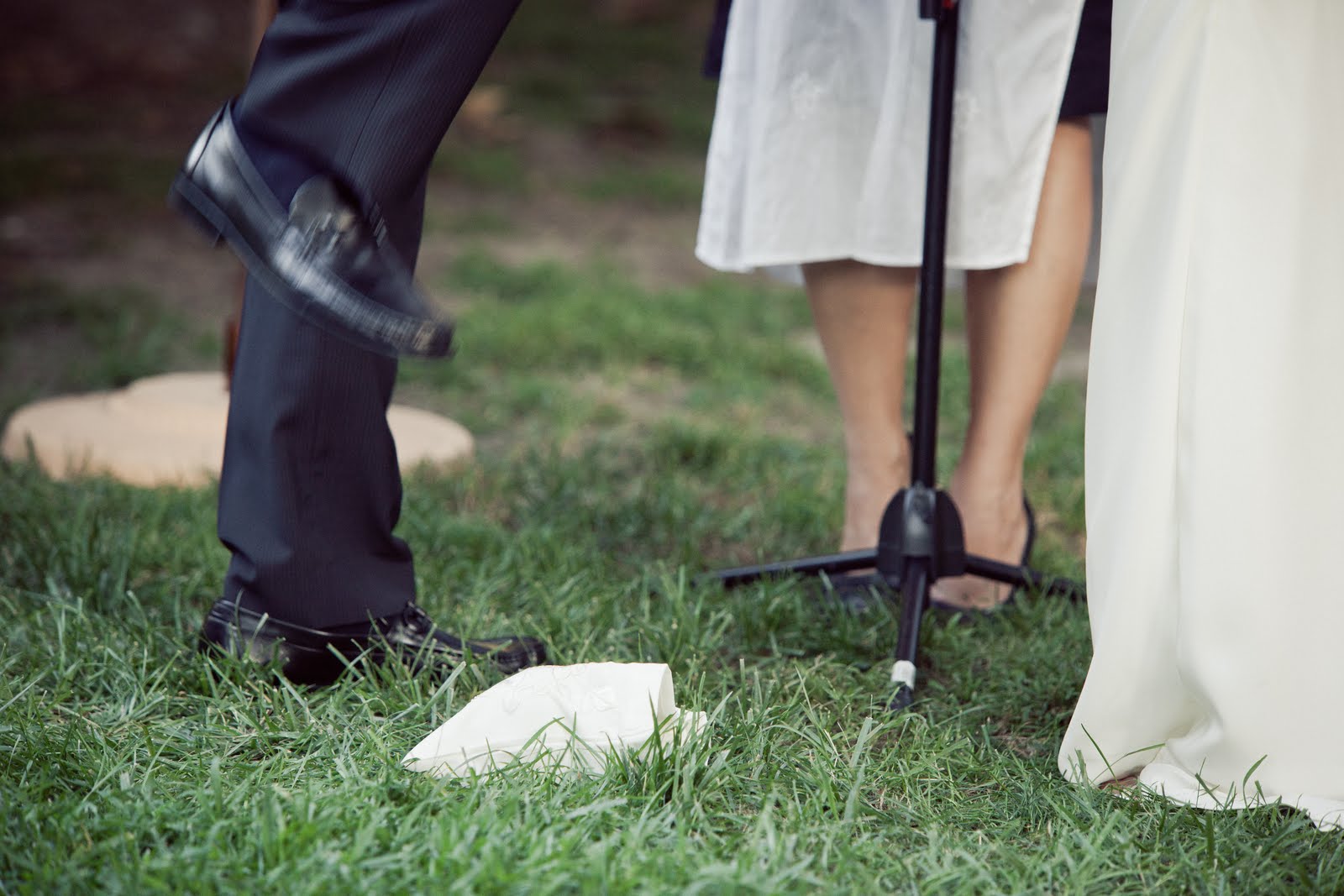 Wedding couple's legs standing on grass with microphone stand