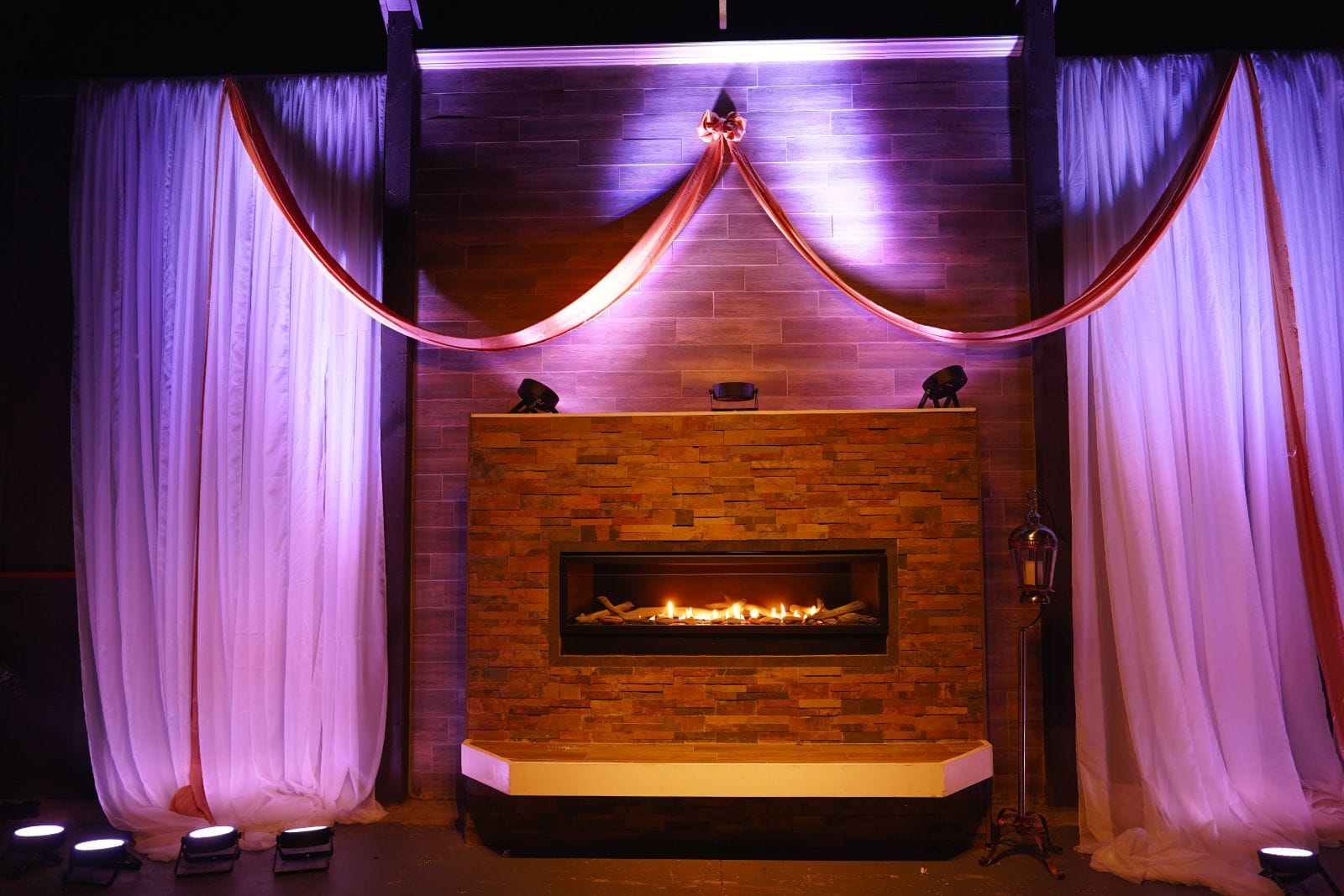 Elegant fireplace with purple curtains and dramatic lighting