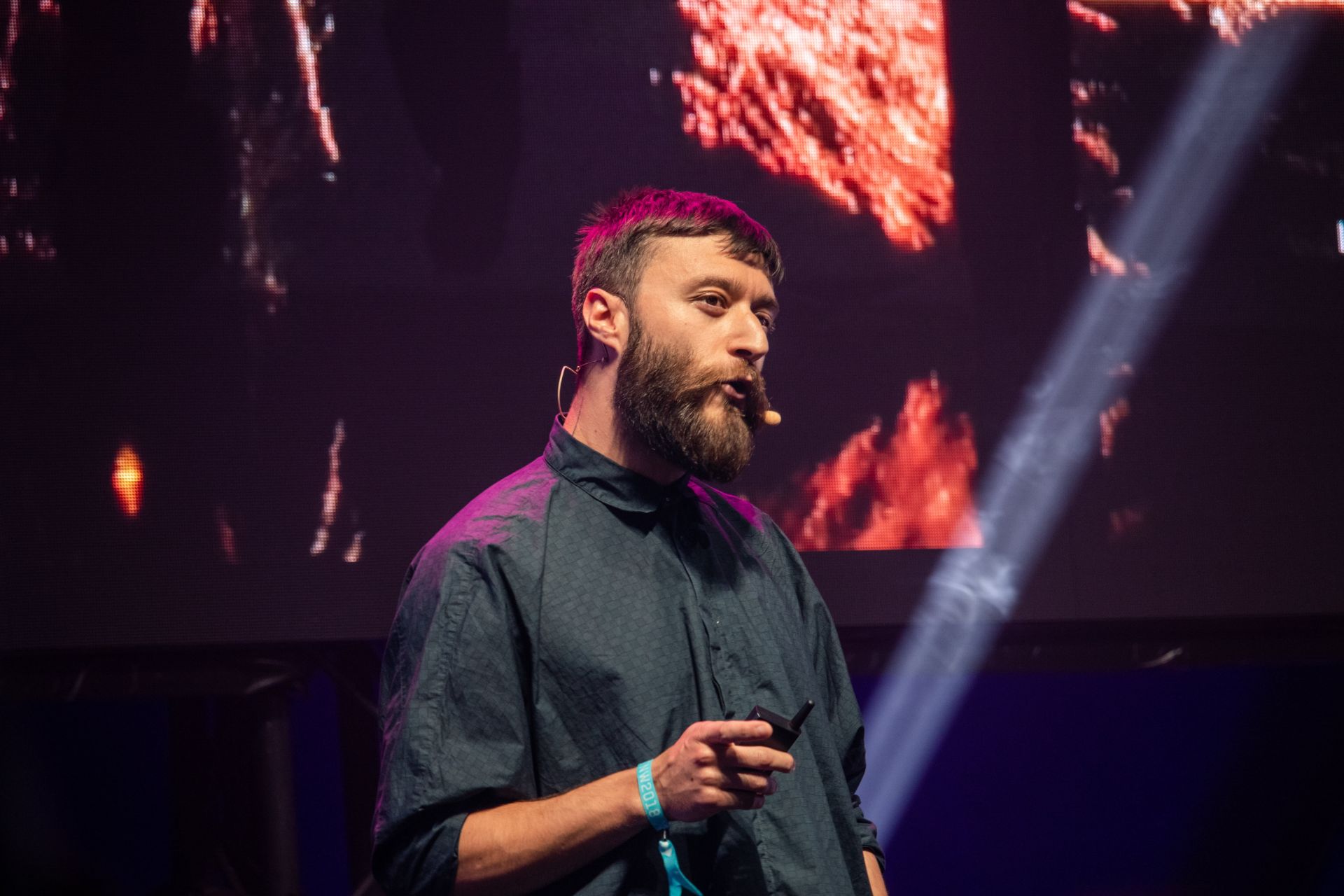 Speaker with microphone on stage with dramatic red background lighting