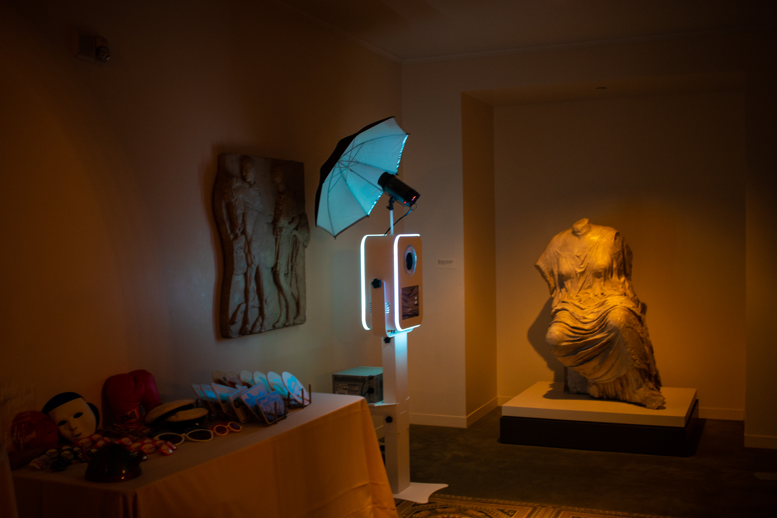 Museum exhibit with blue lighting, statue, and photography equipment