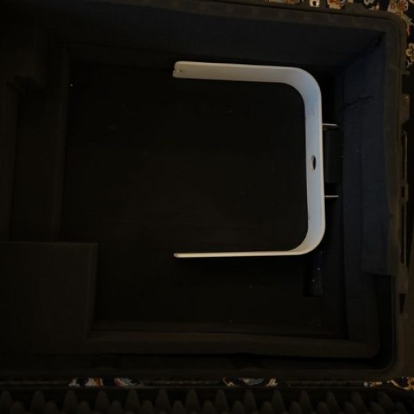 White curved device mounted inside dark framed enclosure