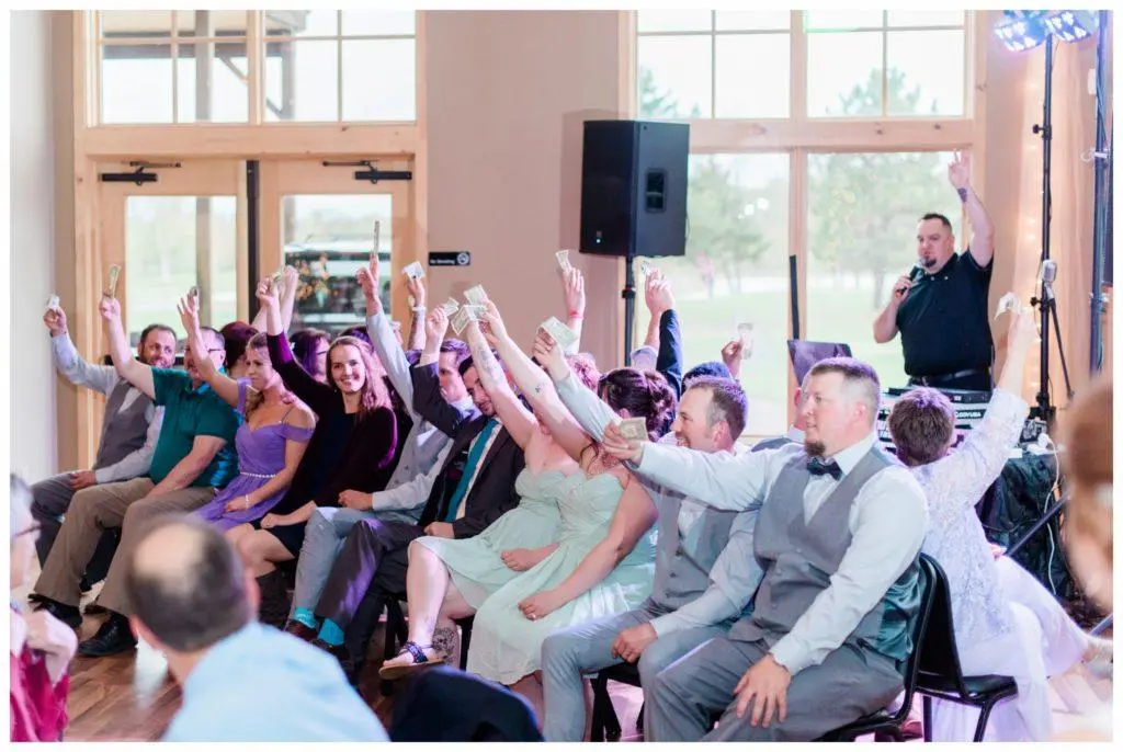 wedding guests laughing and participating in interactive reception games hosted by a DJ during cocktail hour at a Pacific Northwest wedding