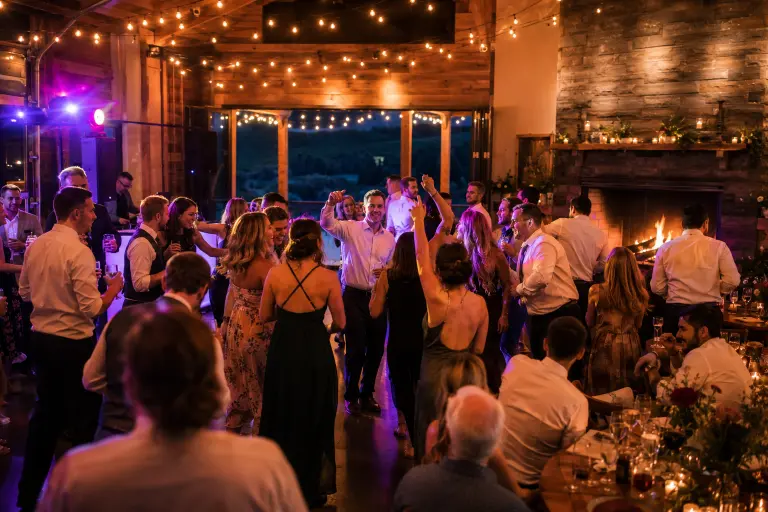 Zenith Vineyard Oregon wedding reception with warm event lighting fireplace dance floor and vineyard evening atmosphere as celebration builds 