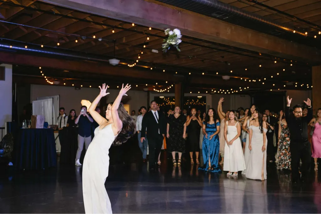Bride tossing her bouquet to guests during the reception at Castaway Portland Wedding Venue in Portland, Oregon.