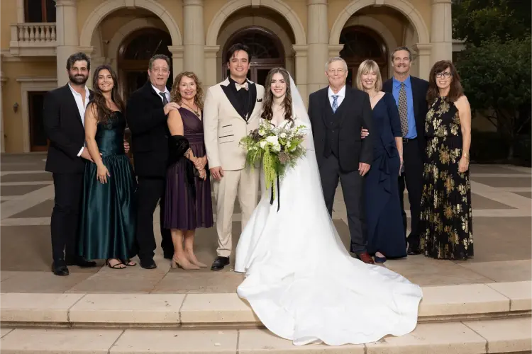 Bride and groom posing with their family in front of Del Mar Villa, one of the top wedding venues in Portland Oregon, during an elegant outdoor wedding celebration.