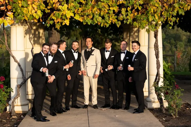 Groom and groomsmen posing beneath a vine-covered pergola at Del Mar Villa, one of the top wedding venues in Portland Oregon, during an elegant outdoor wedding celebration.