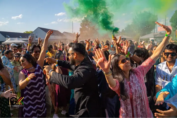 Guests dancing with colorful powder during a lively pre-wedding celebration, featured in the Indian Wedding Guide on Indian wedding traditions and events.